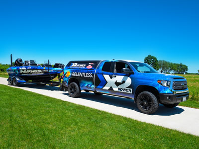 A pickup truck with an X2Power wrap pulling a boat with an X2Power wrap