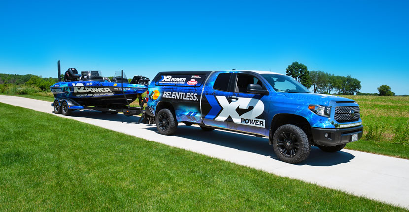 A pickup truck with an X2Power wrap pulling a boat with an X2Power wrap