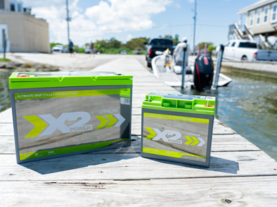 Two X2Power lithium marine batteries sitting on a pier