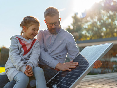Father and daughter looking at a solar panel