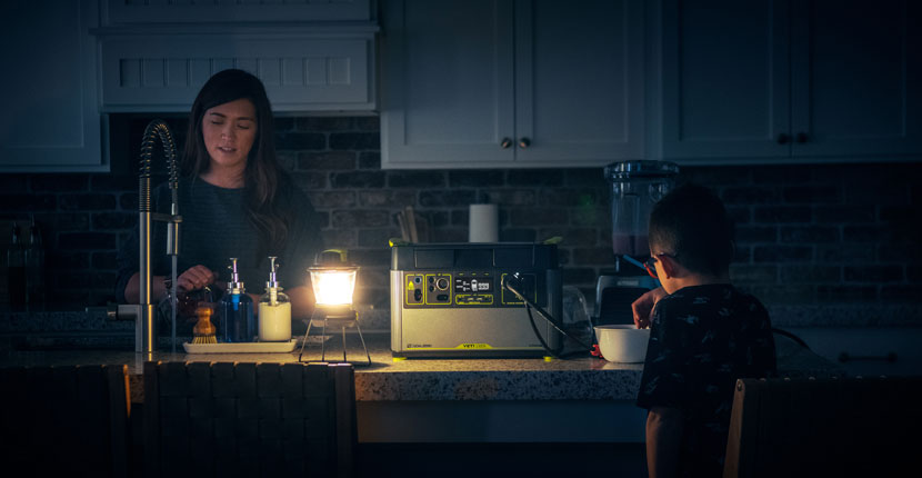 Mother and son in a kitchen with a lantern using a Goal Zero generator to power some appliances