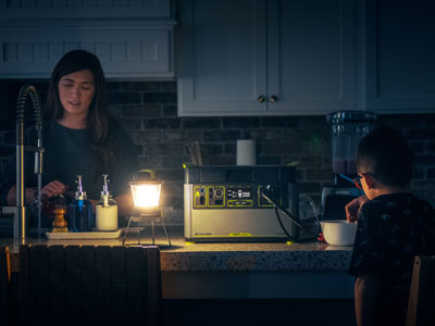 Mother and son in a kitchen with a lantern using a Goal Zero generator to power some appliances