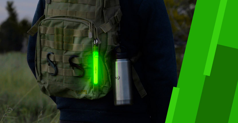 Person wearing a backpack with a water bottle and a glow stick