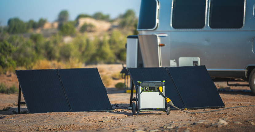 Goal Zero generator and solar panels near a camper
