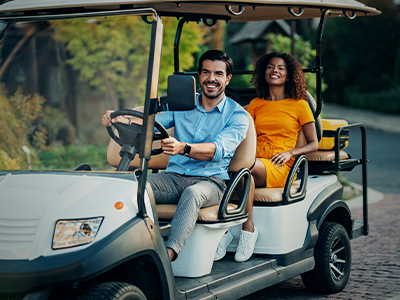Two people riding in a golf cart