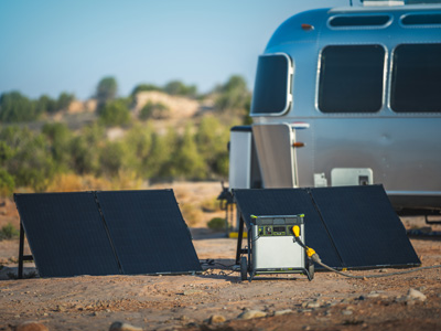 Goal Zero generator and solar panels near a camper