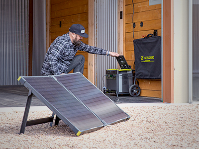 Man using solar panels to charge a portable generator