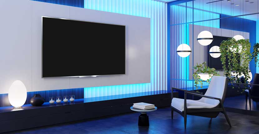 Blue lit room with a tv and mirror wall