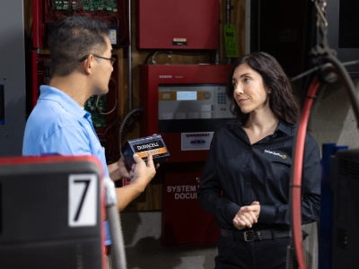 Employee holding a sla battery talking to a customer