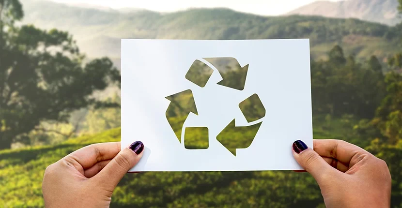 Holding up a card with recycling symbol