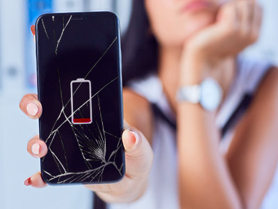 Woman holding a broken phone in front of her