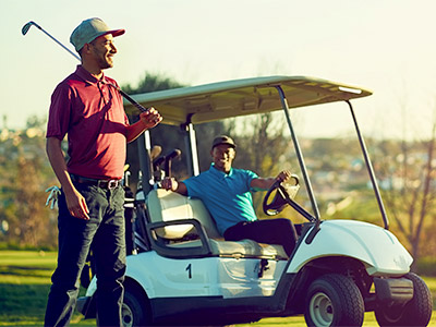 golfer standing next to a golf cart