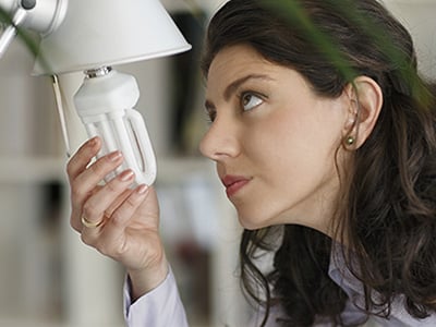 Woman replacing a light bulb in a lamp