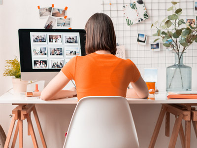 Woman in orange shirt working at an at-home office