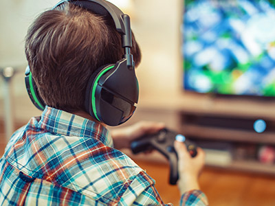 Child playing a video game with wireless headphones and controller