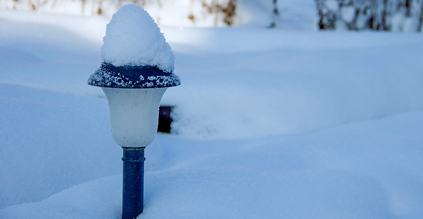 Solar powered light covered with snow