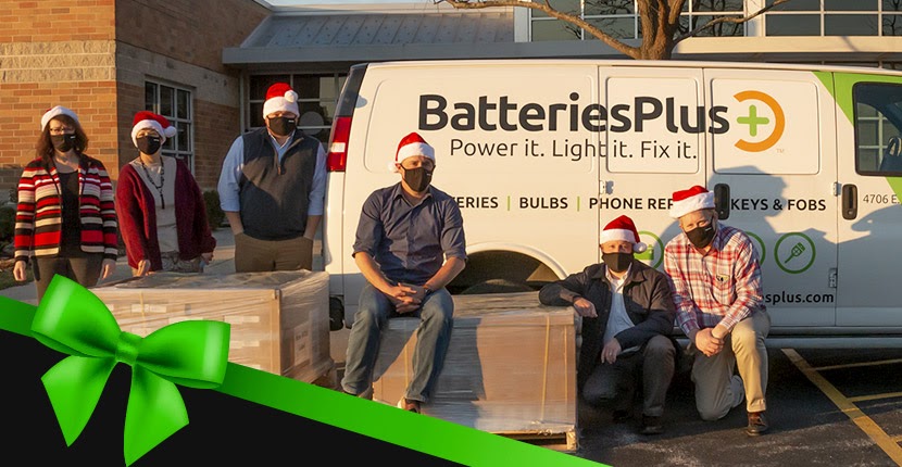Batteries Plus Bulbs employees in front of van with pallets of collected toys