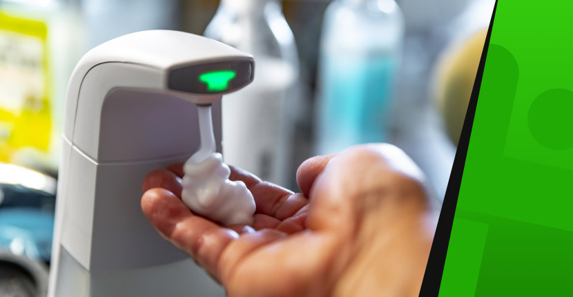 Hand gathering foam hand sanitizer from a touchless sanitizing station