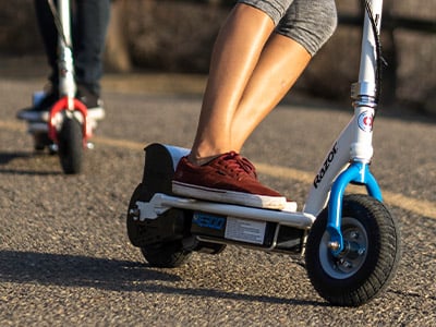two people riding on an electric scooter