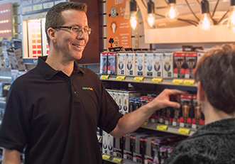 Store employee showing a customer light bulbs
