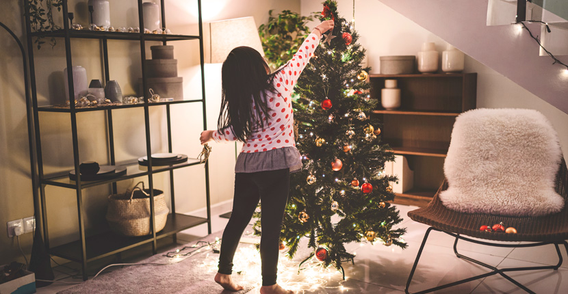 Little girl decorating a Christmas tree
