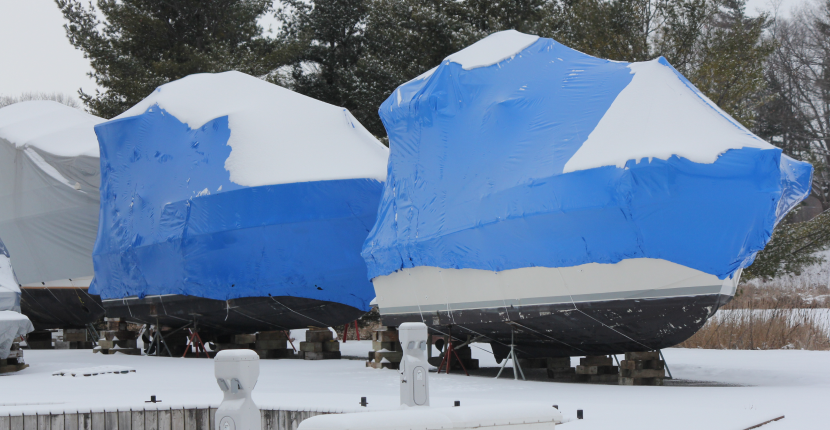Boats in storage with snow on the covers