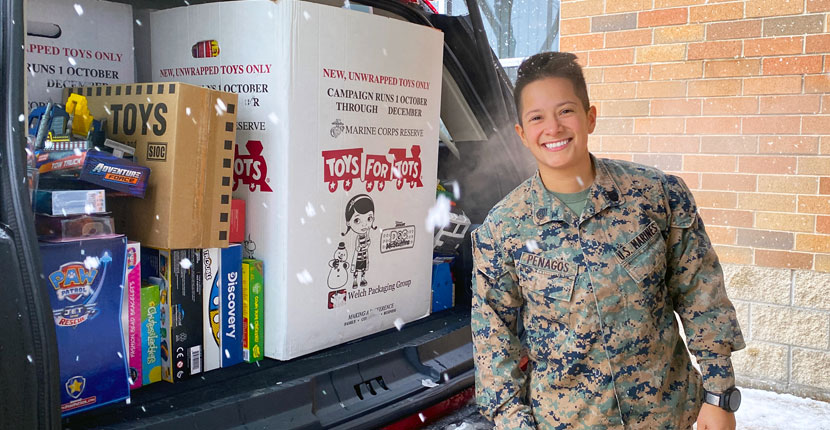Marine Staff Sergeant Penagos standing in front of items donated to Toys for Tots