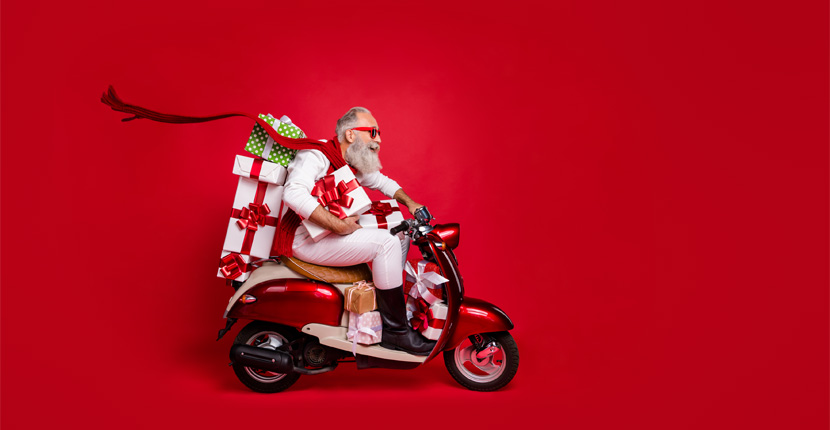 Santa riding on a scooter with gifts