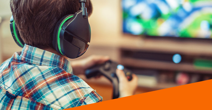 Child playing a video game with wireless headphones and controller