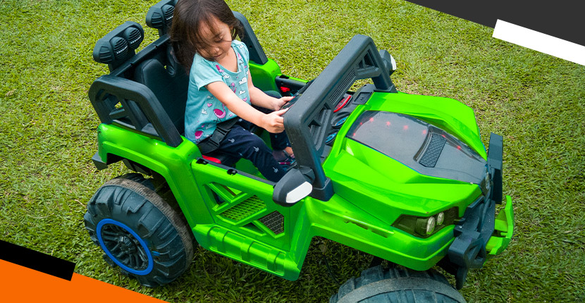 little girl riding in a green riding toy