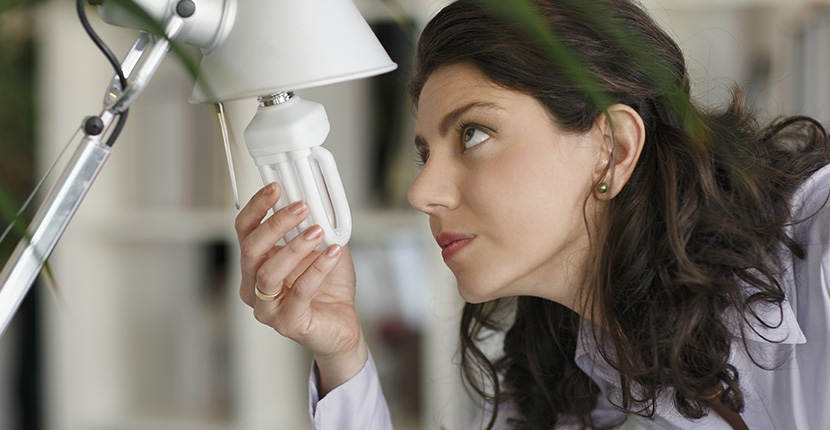 Woman replacing a light bulb in a lamp
