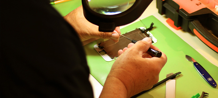 Working on a cell phone screen on a green mat