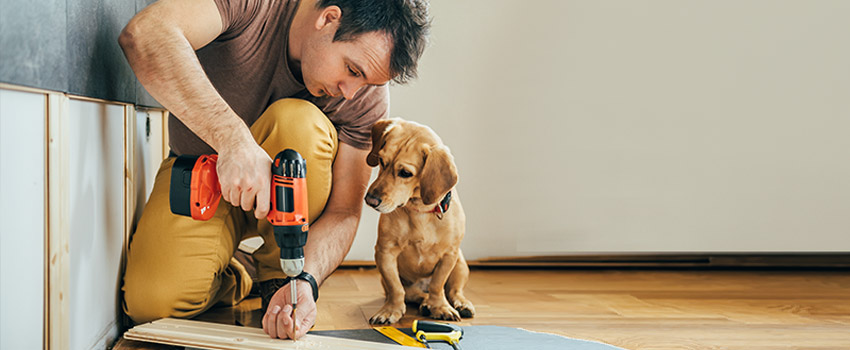 A man doing work with a puppy next to him