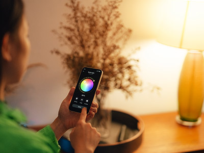 Person controlling the color of a smart bulb with their phone