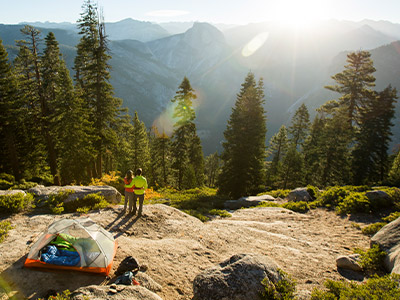Couple camping in the woods overlooking a cliff