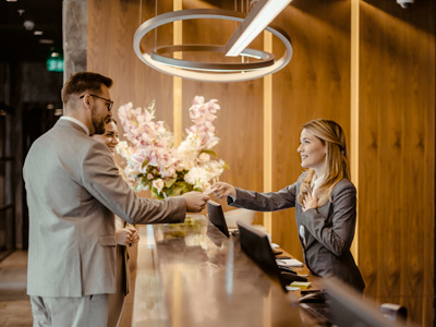 Hotel employee handing a room card to a couple